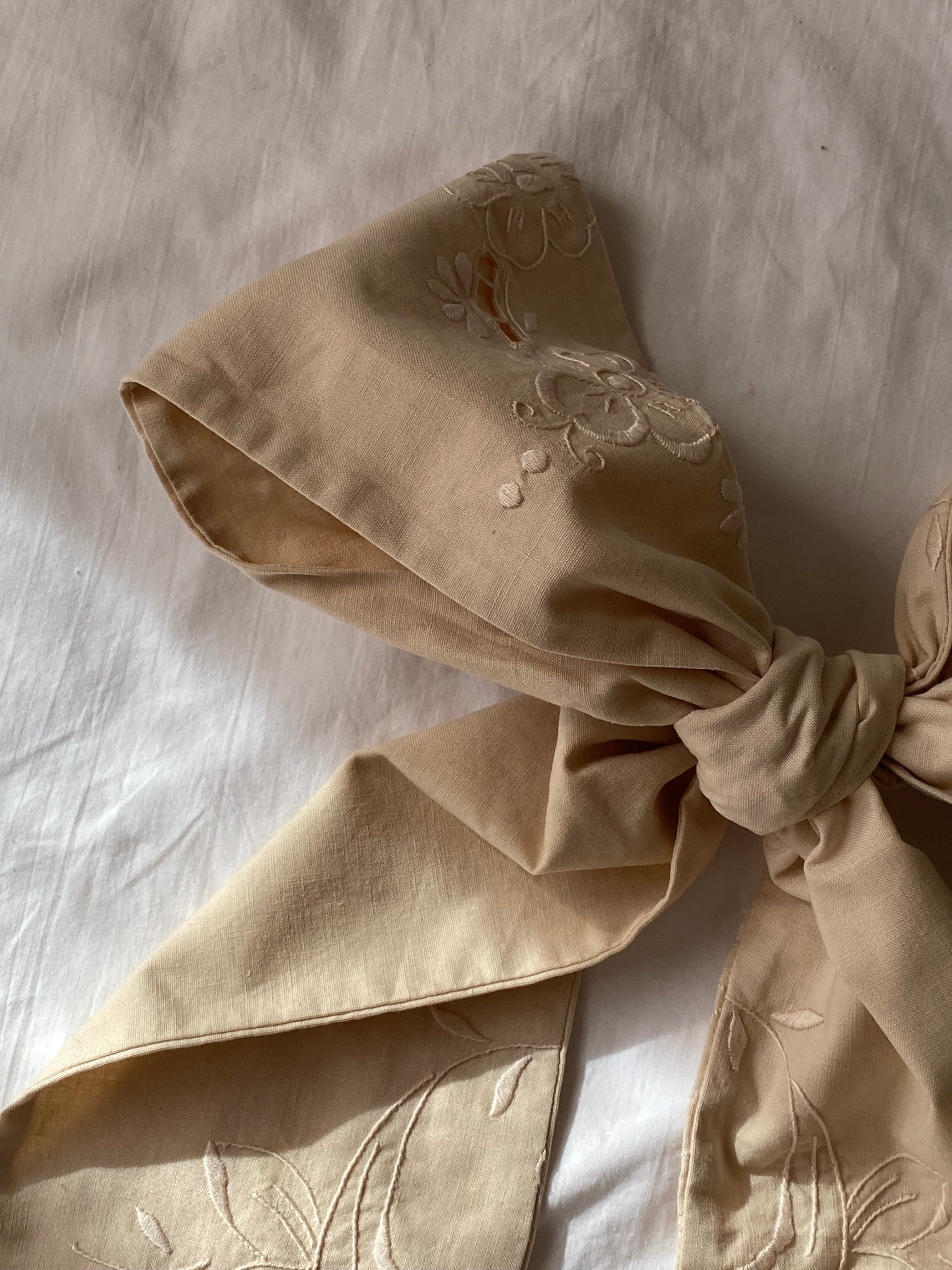 Tailored bow with antique embroidery