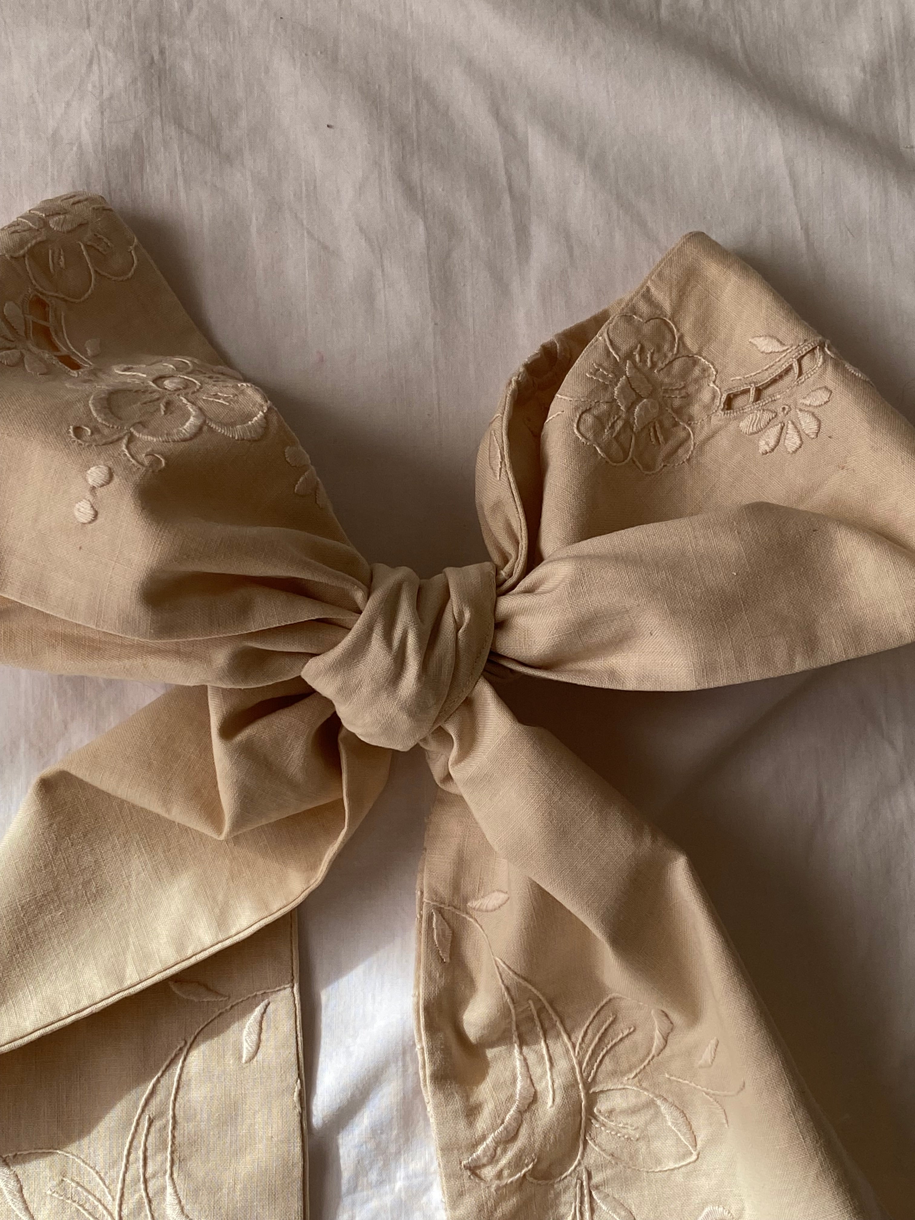 Tailored bow with antique embroidery